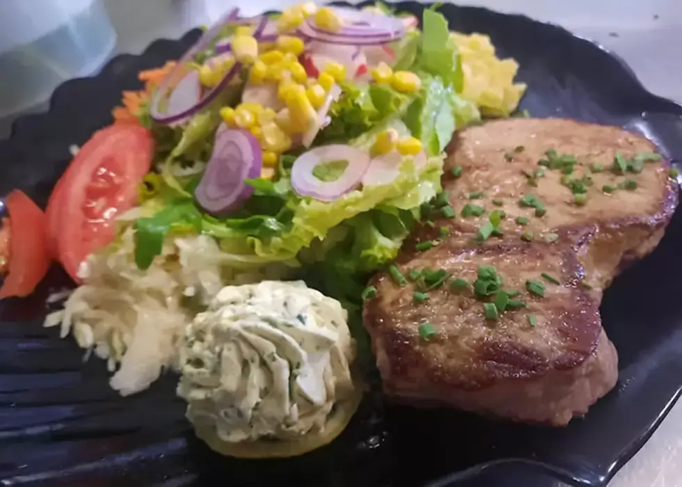 Schweinemedaillons knusprig gebraten mit Salat und Kräuterbutter